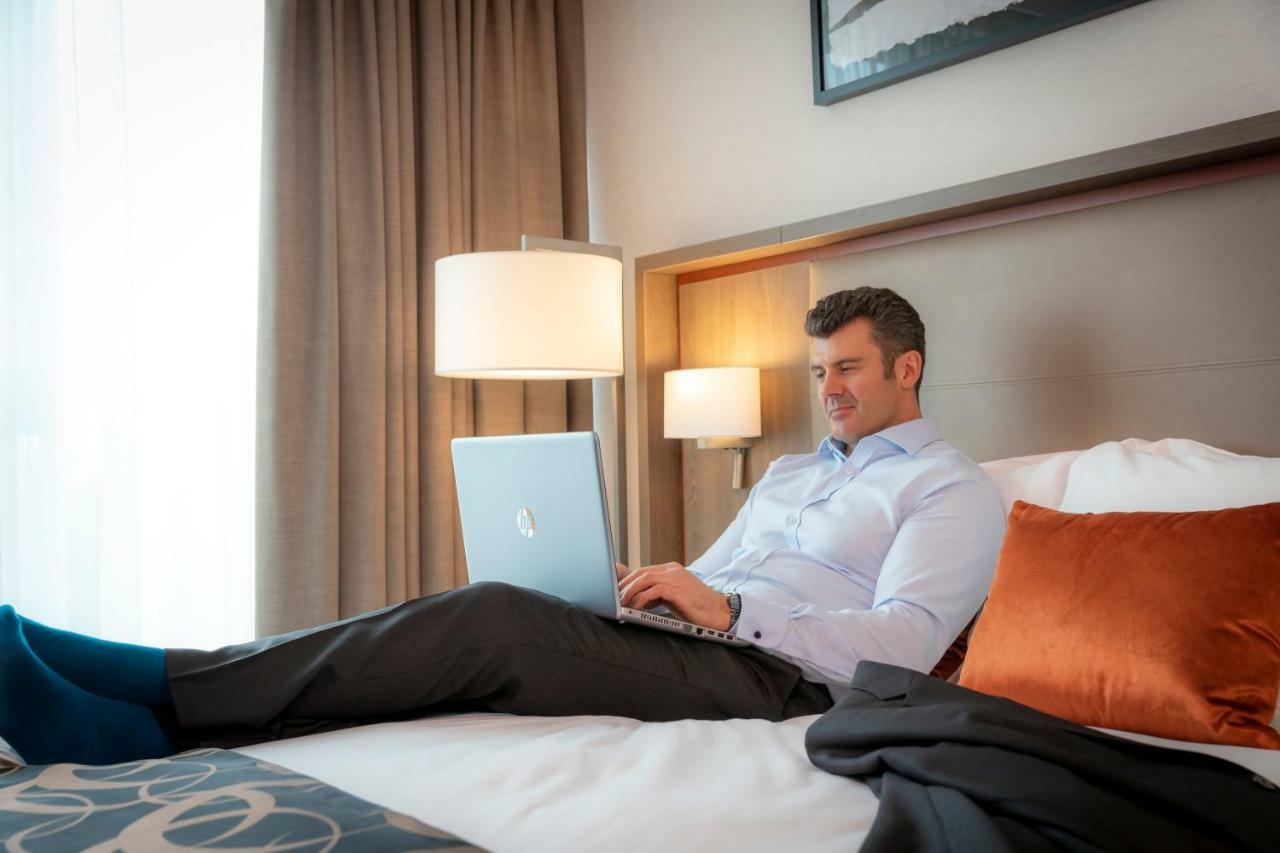 Clayton Hotel Dublin Airport Coolock Dış mekan fotoğraf A man working on a laptop in a hotel room